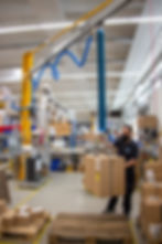 Hebehilfe von Best Handling Technology: Vakuumheber ezzFAST am Portalkran ezzLINKrack beim Umsetzen von Kartons.