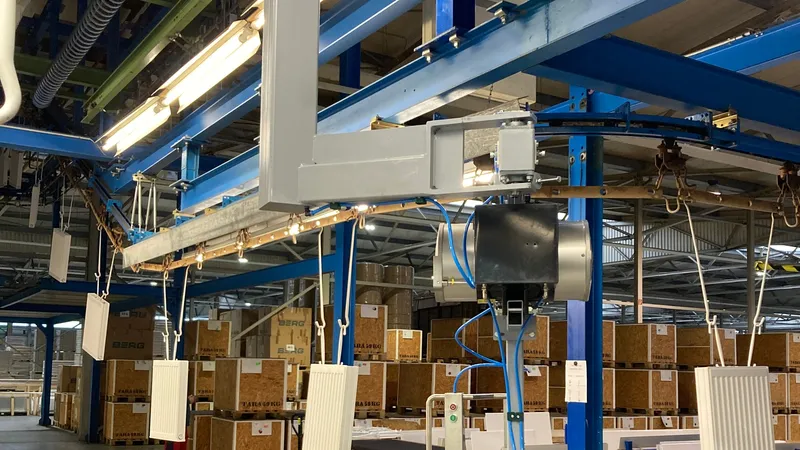 ezzFLOW balancer loading a radiator onto the conveyor of a powder coating line.