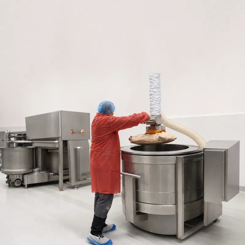 ezzFAST vacuum lifter positioning a sack above the opening of a mixer.